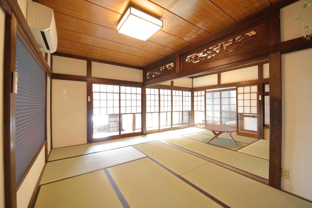 um quarto vazio com janelas e uma mesa em ファミリー&釣り好きに大人気の宿-松部漁港まで徒歩1分 em Katsuura