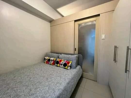une chambre avec un canapé dans une chambre avec une porte dans l'établissement condotel staycation for rent tower E&F, à Manille