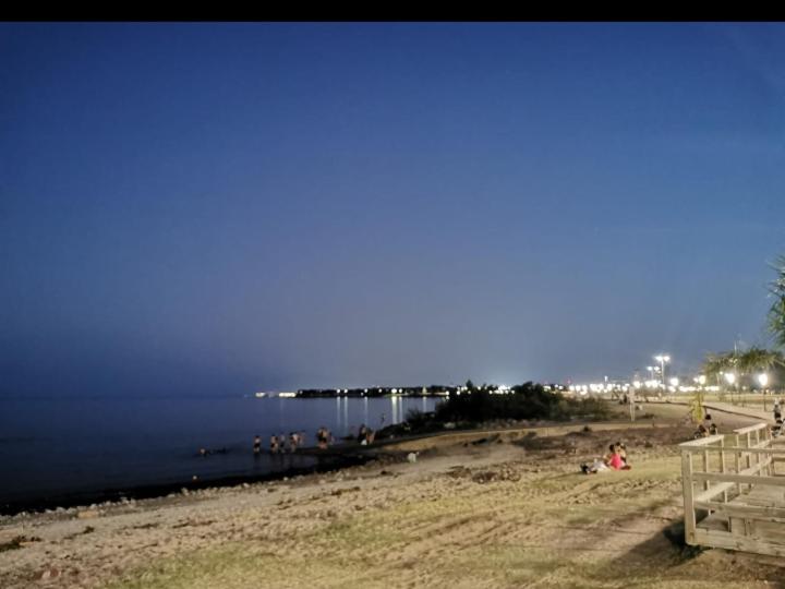 een groep mensen op een strand bij het water bij La Morada de Vicente López in Vicente López