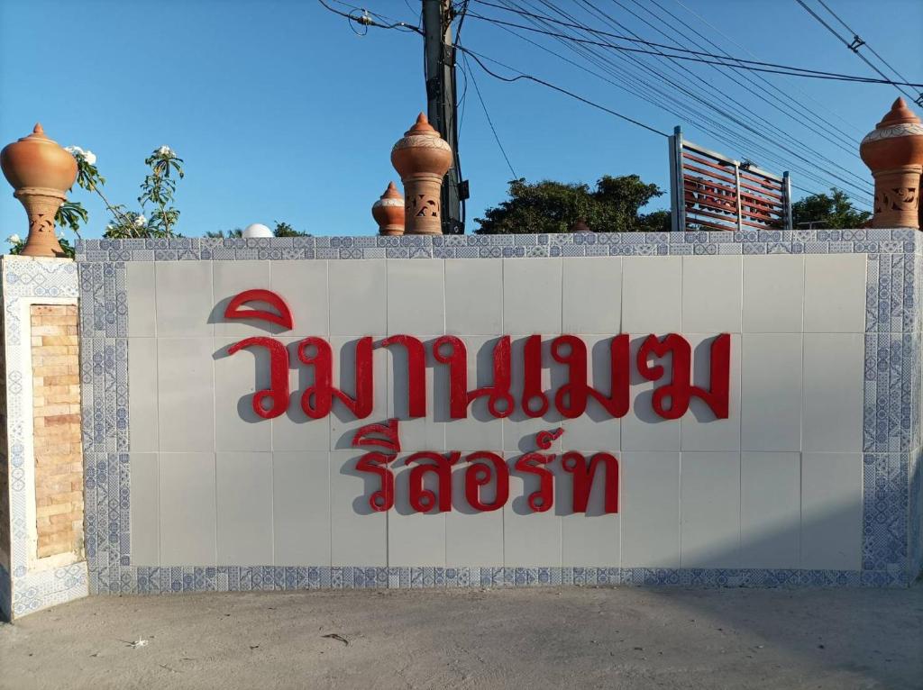 a sign for a jumeirah store on a wall at Vimanmek Resort in Yasothon