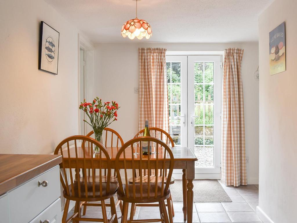 a dining room with a table and chairs and a window at Dove Cottage in South Hill