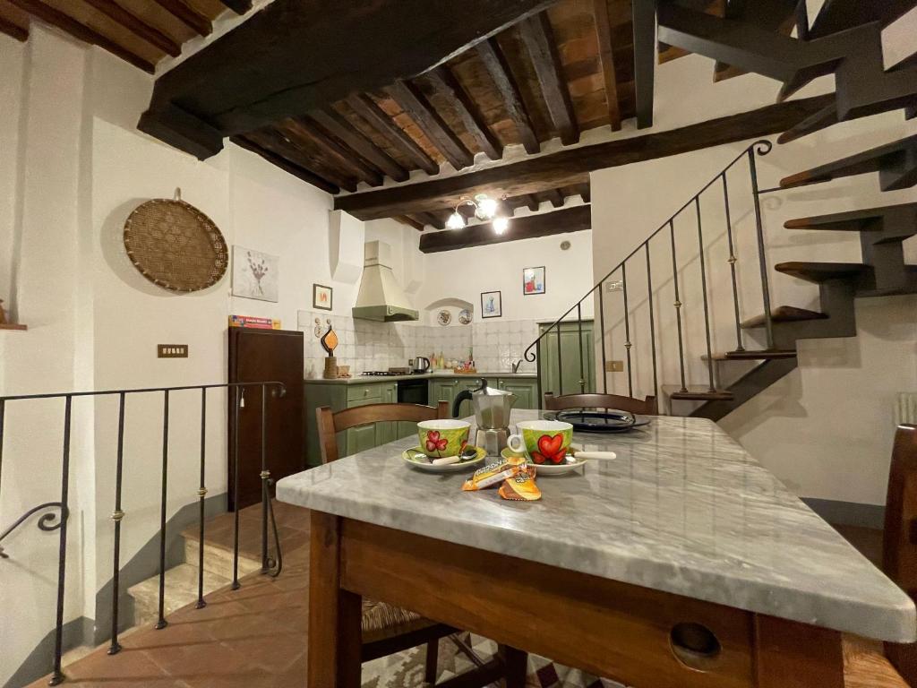 a kitchen with a table with fruit on it at PULCINELLA appartamento tipico centro storico in Montepulciano