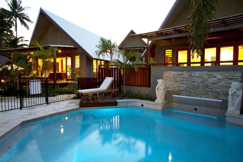 a house with a swimming pool in front of a house at Pure Magnetic Villa 6 in Nelly Bay