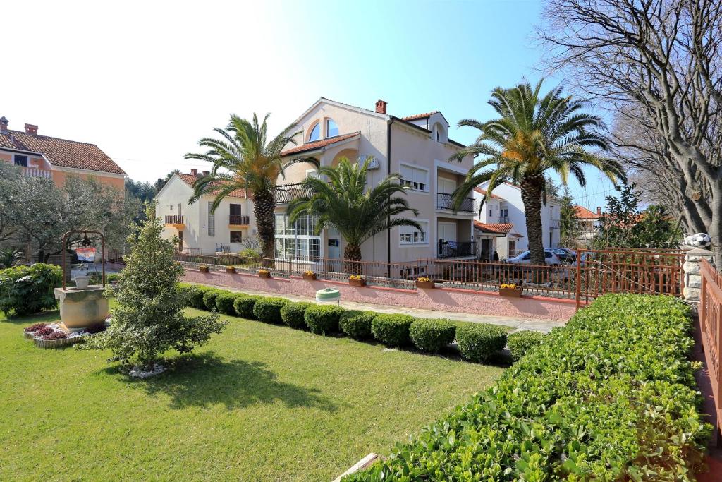 a large house with palm trees in a yard at Villa Dalmatia in Zadar