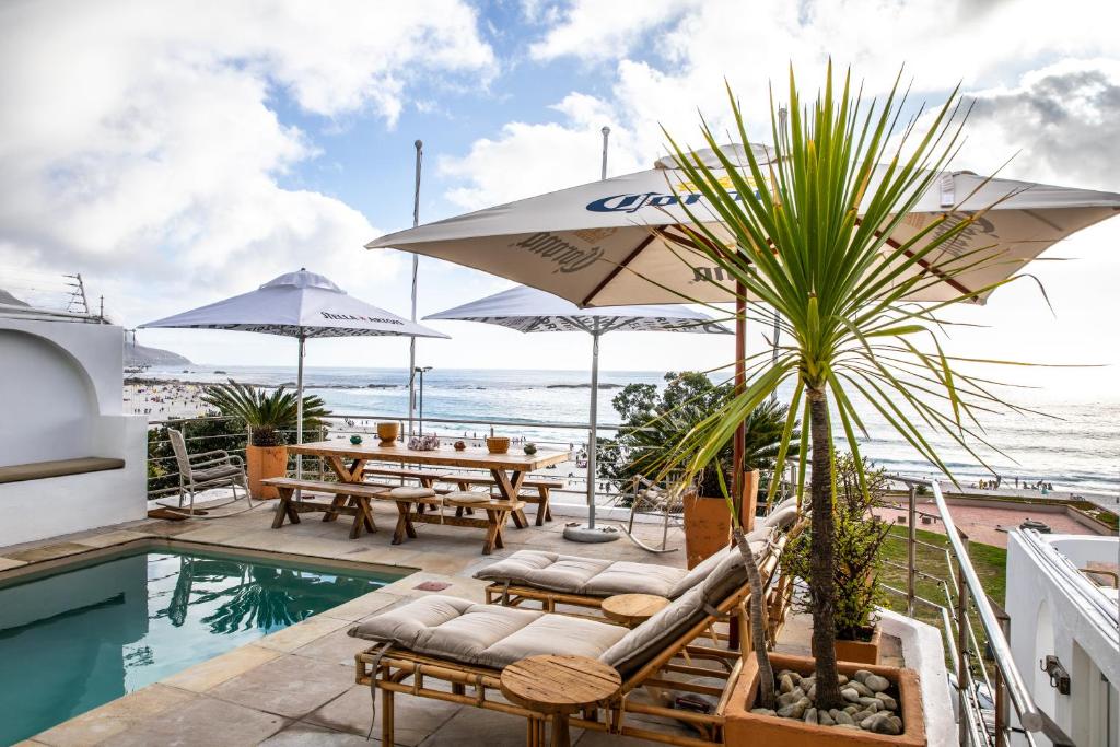 um pátio com uma mesa e cadeiras e uma piscina em Primi Seacastle em Cidade do Cabo