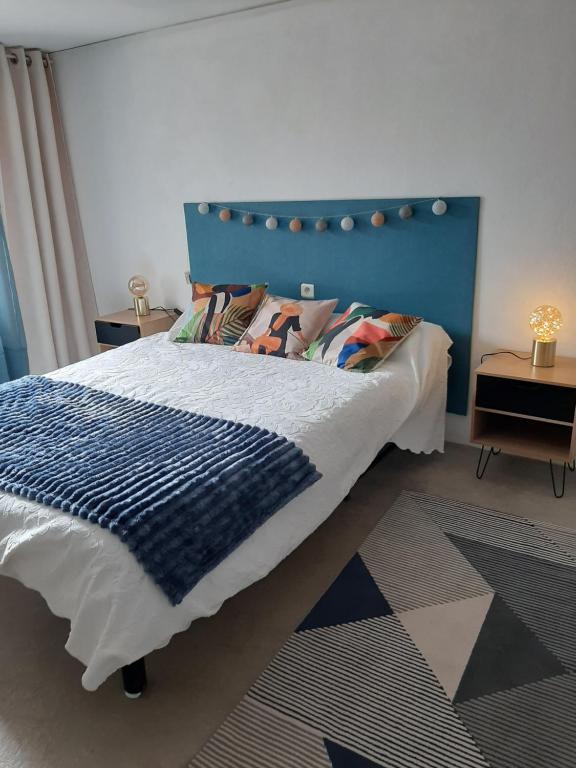 un letto con testiera blu in una camera da letto di Chambre d'hôte Chez Josie a Beaucaire