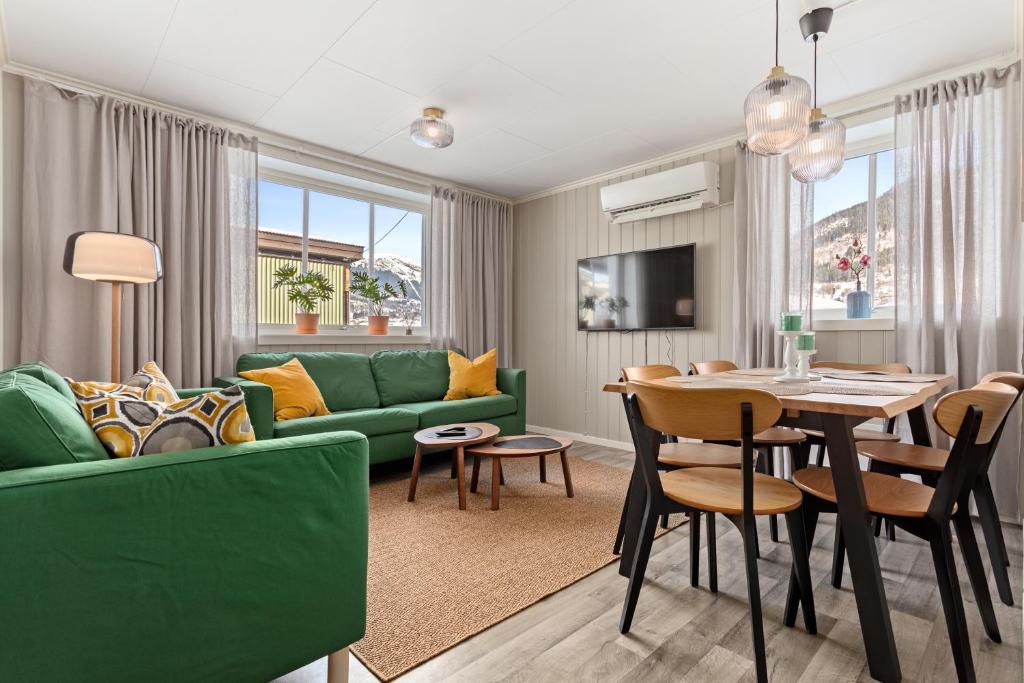 ein Wohnzimmer mit einem grünen Sofa und einem Tisch in der Unterkunft Sagi 1 Privat Apartment in Hafslo
