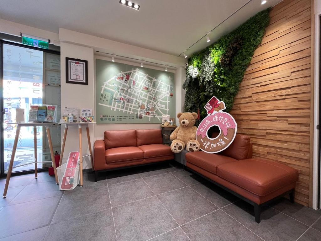 a waiting room with a teddy bear sitting on a couch at 信然文旅-首學 寵物友善預訂前務必事先詢問 in Tainan