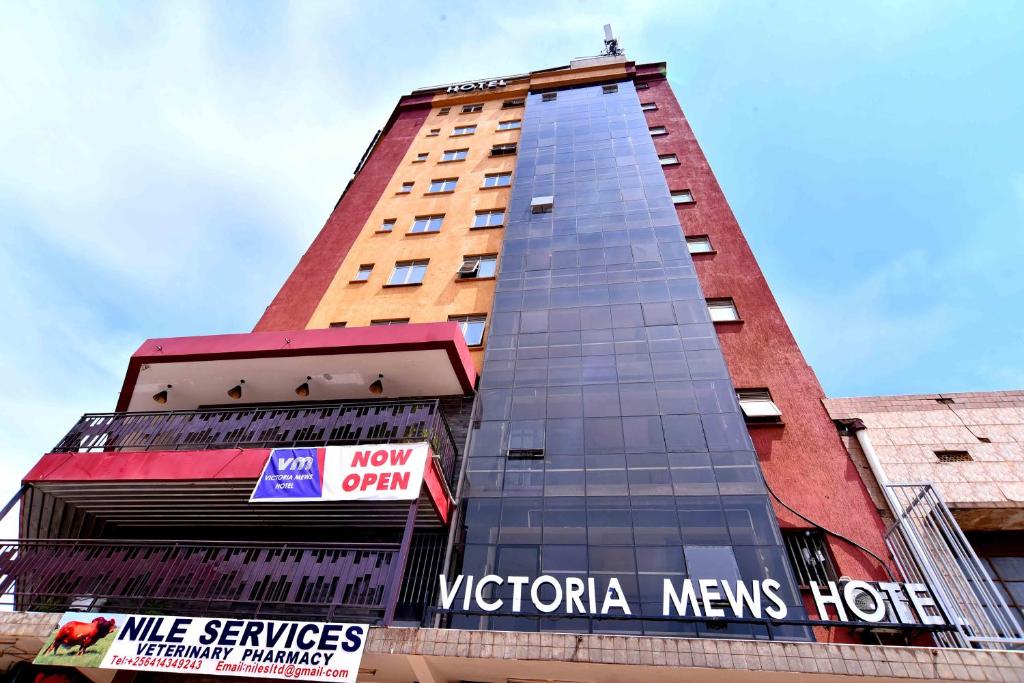 a tall building with a sign in front of it at Victoria Mews Hotel in Kampala