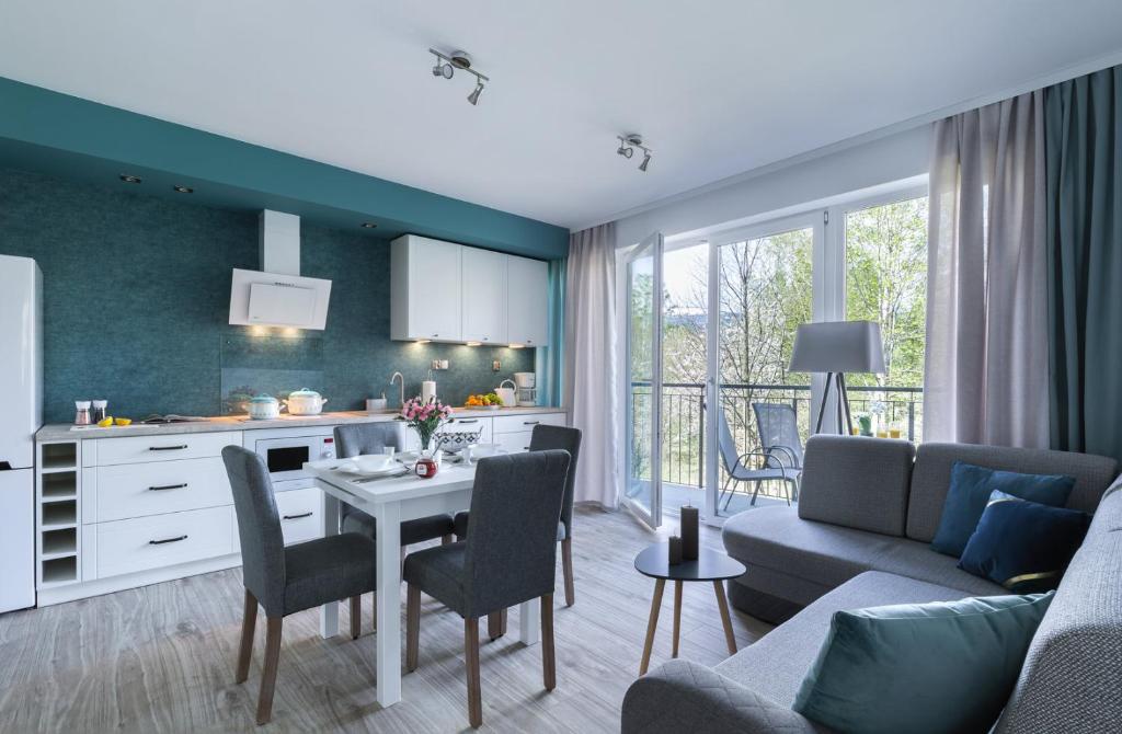 une cuisine et un salon avec une table et un canapé dans l'établissement APARTAMENT KONOPNICKIEJ 11/23, à Karpacz