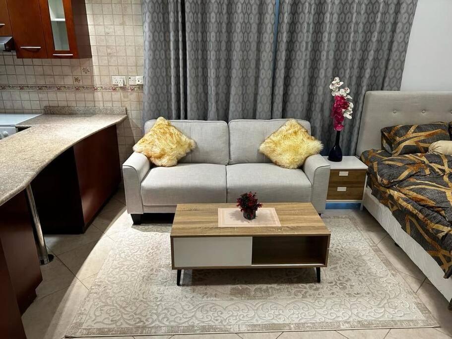 a living room with a couch and a coffee table at Rayyan Stays in Dubai