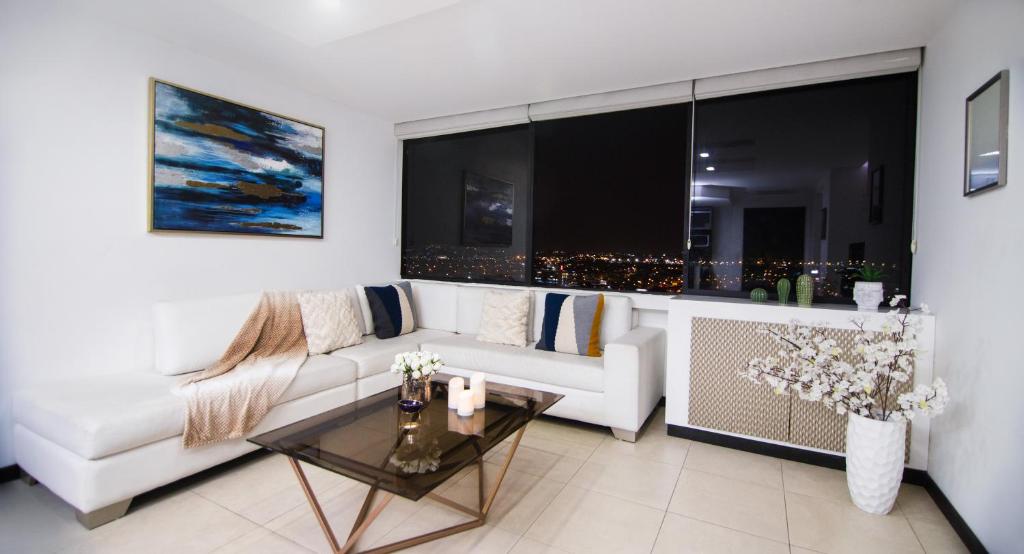 a living room with a white couch and a table at Puerto Santa Ana Luxury Suites Guayaquil in Guayaquil