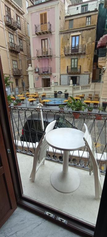 un tavolo bianco su un balcone con vista sulla città di Casa Rosmary a Cefalù