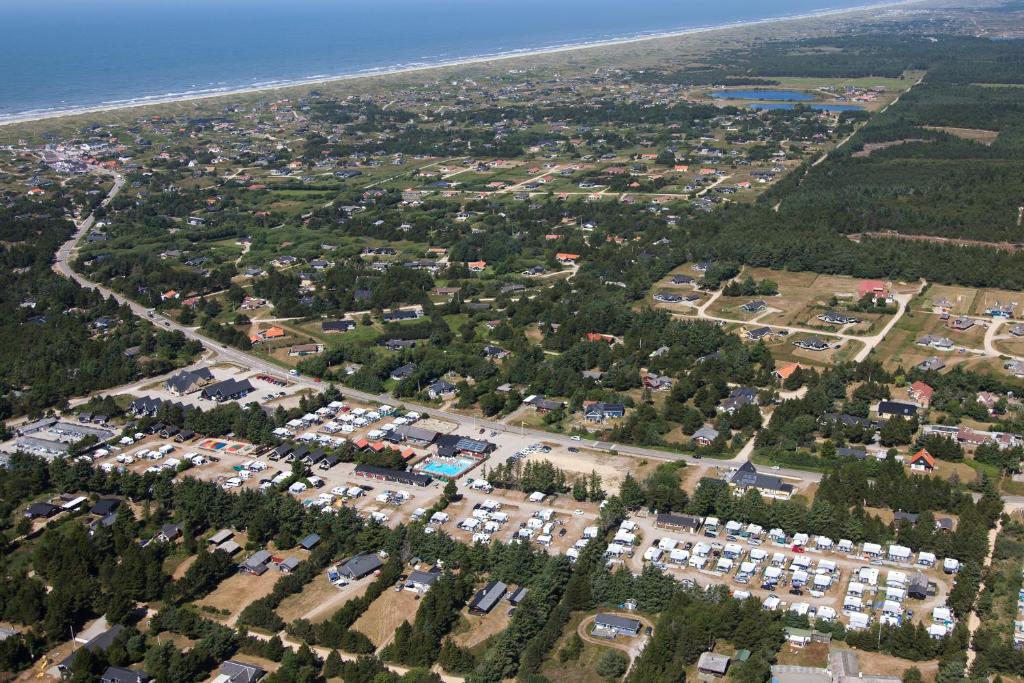 an aerial view of a parking lot next to the ocean at Vejers Family Camping & Cottages in Vejers Strand