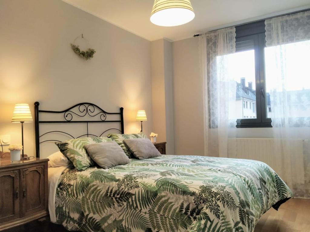 Apartamento en OVIEDO,WIFI في أوفِييذو: غرفة نوم بسرير مع نافذة كبيرة