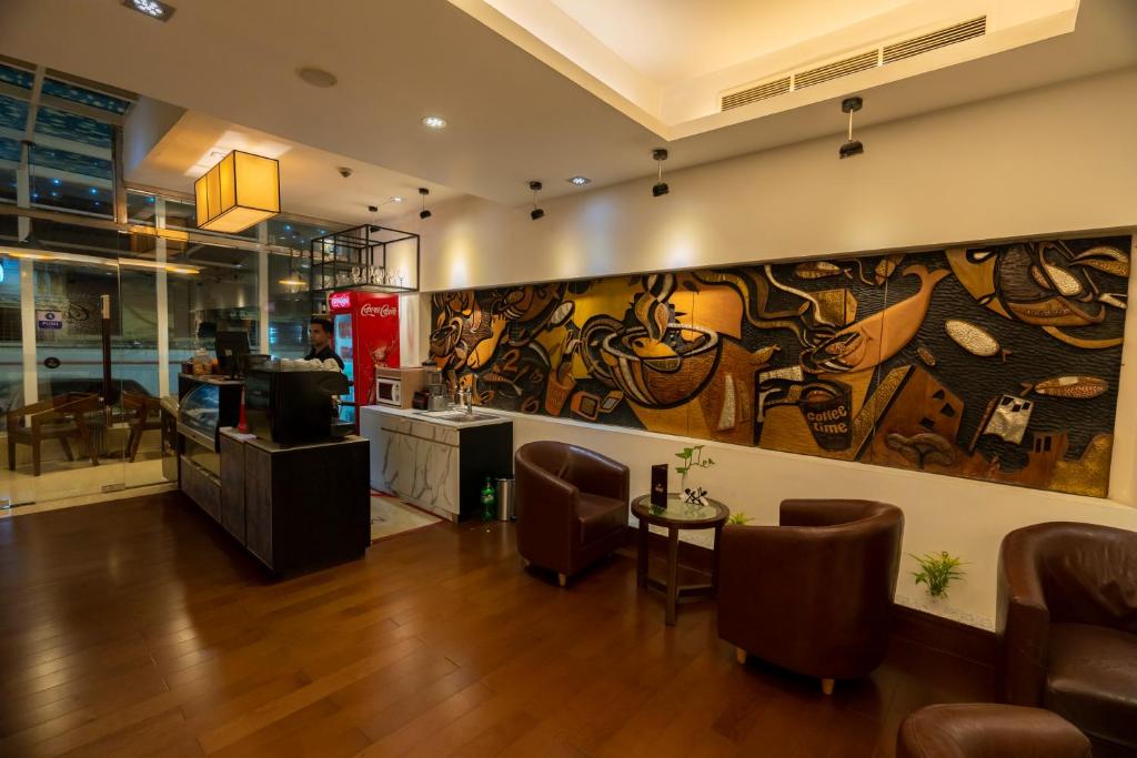 a restaurant with a large painting on the wall at Hotel Bengal Canary Park in Dhaka