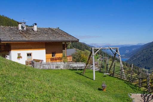 una casa al lado de una colina con un tobogán en Biohof Unterstein, en Ultimo