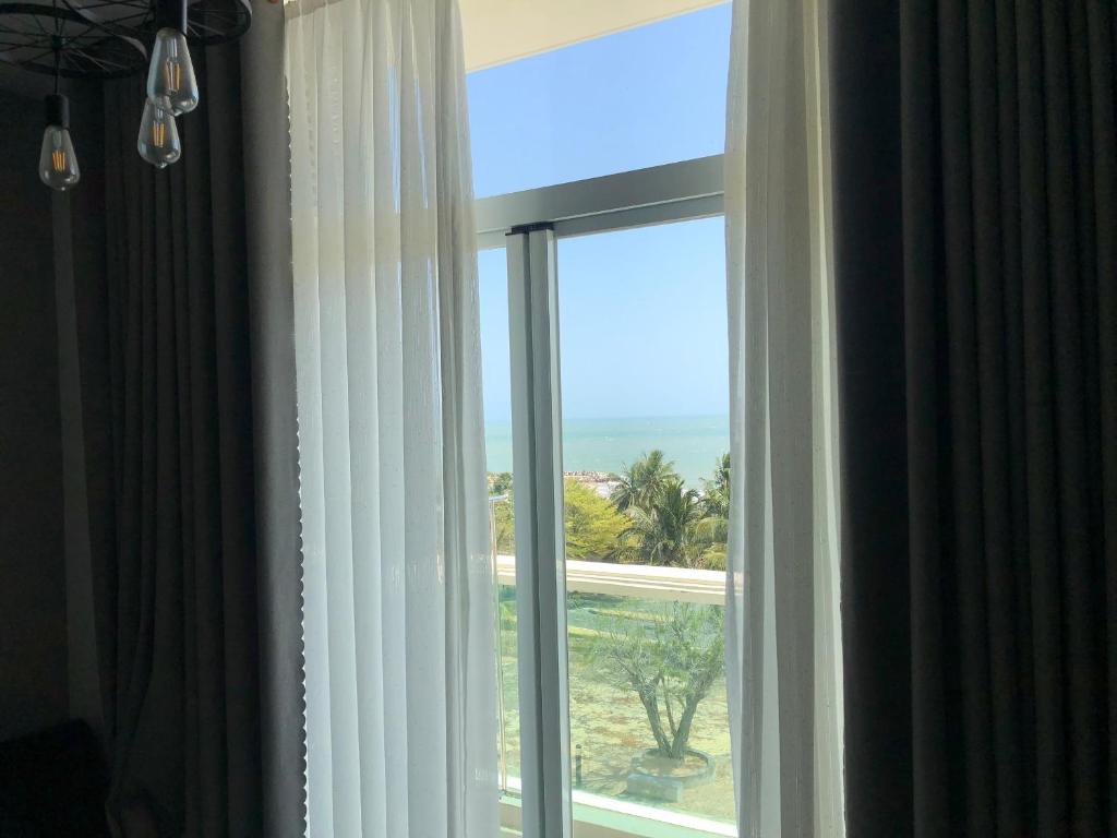 a window in a hotel room with a view of the ocean at Căn hộ 1br Ocean Vista - SeaHome in Phan Thiet