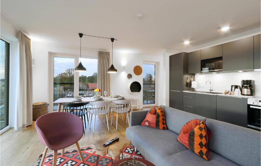 ein Wohnzimmer mit einer blauen Couch und einer Küche in der Unterkunft Beach Front Apartment in Lembruch