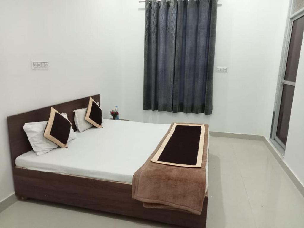 um quarto com uma cama com um banco em DIPEN GUEST HOUSE em Alwar