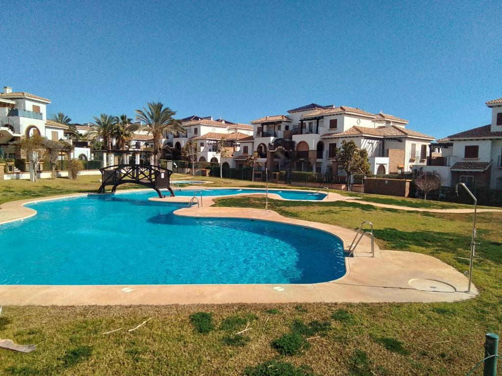 een zwembad in een tuin met enkele huizen bij THALLASA APARTMENT VERA PLAYA in Playas de Vera