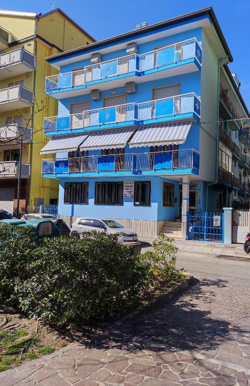 a blue building with blue balconies on a street at Appartamenti Padoan in Sottomarina