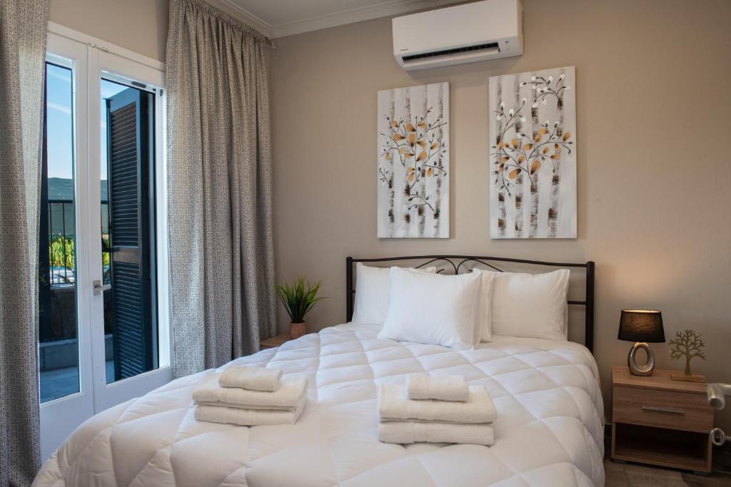 Un dormitorio con una cama blanca con toallas. en Katerina's Place en Argos