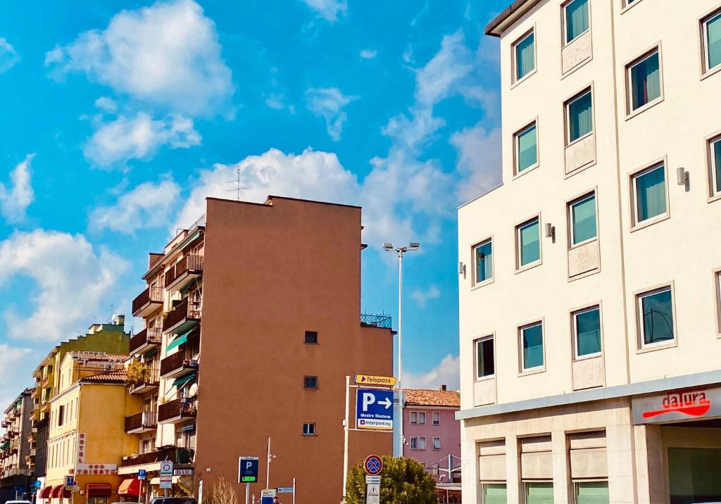 una calle de la ciudad con edificios altos y un cielo azul en Pang's Guesthouse, en Mestre