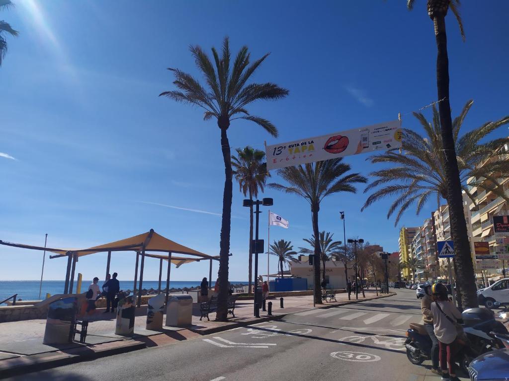 a city street with palm trees and a beach at Anuli & Beach & Family - Fuengirola & Malaga in Fuengirola