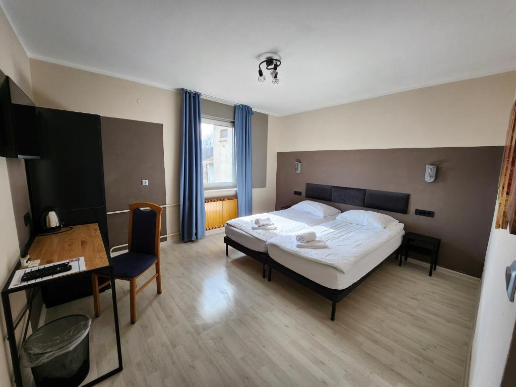 1 dormitorio con cama, mesa y escritorio en Pension Knafel, en Žirovnica