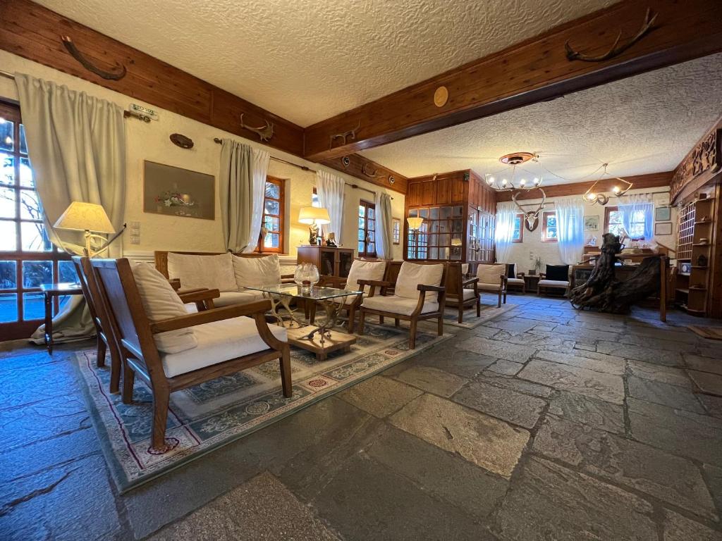 a living room with a lot of chairs and tables at Bourazani Wild Life Resort in Konitsa