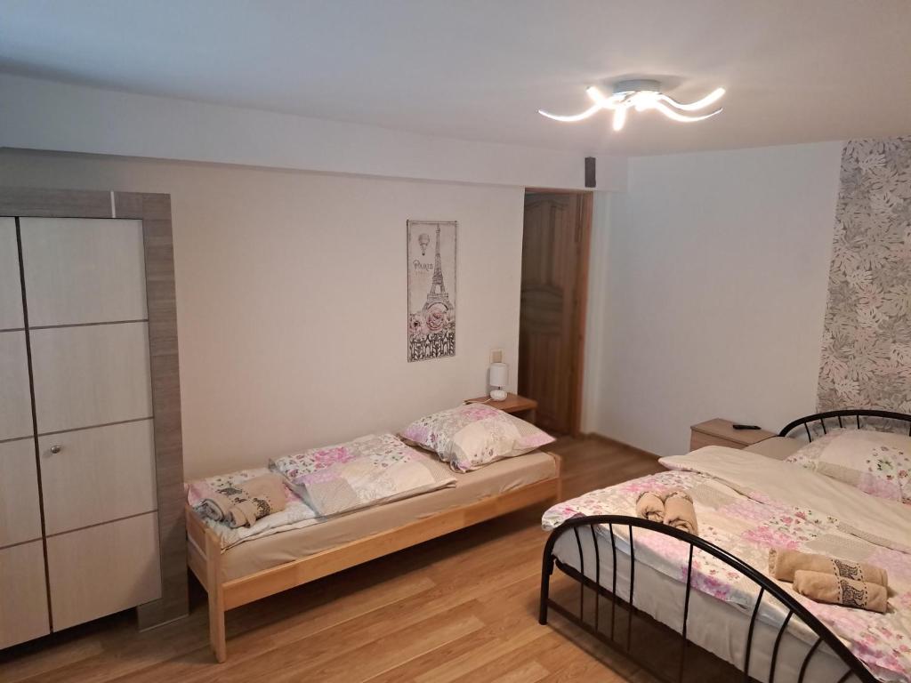 a bedroom with two beds and a chandelier at Mieszkanie na wyłączność in Jeleśnia