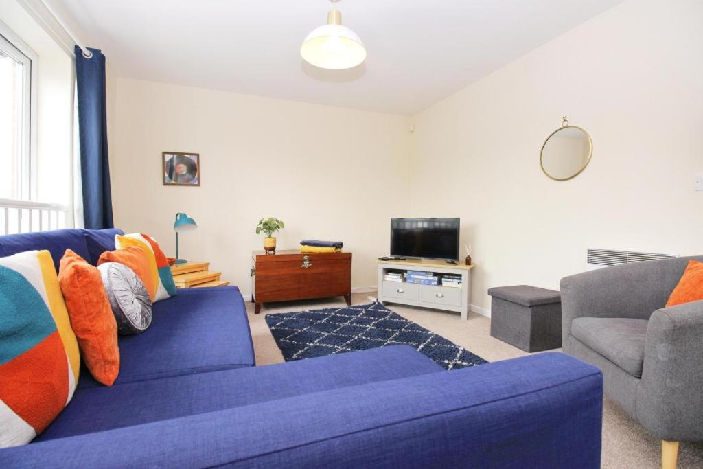 een woonkamer met een blauwe bank en een tv bij Hidden Gem of Newark - Sleeps 6 in Ollerton