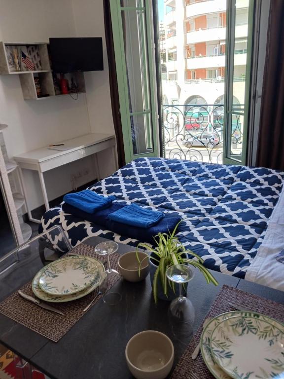 a room with a bed with plates on a table at studio à 2 mn à pied de la plage in Nice