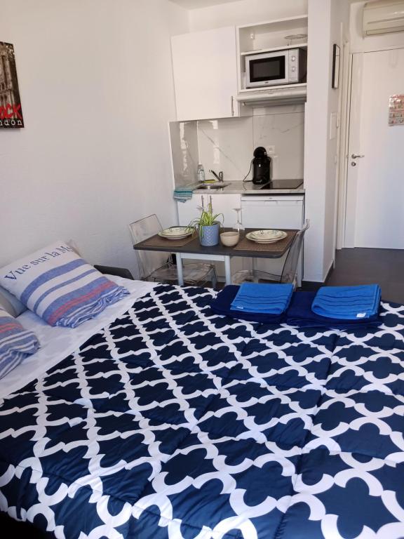 a bedroom with a blue and white comforter on a bed at studio à 2 mn à pied de la plage in Nice