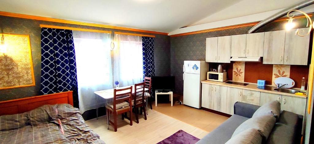 een keuken en een woonkamer met een bank en een tafel bij Be real центр квартира кондиціонер in Ivano-Frankivsʼk