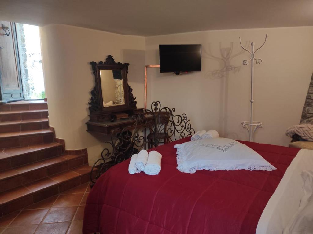 a bedroom with a red bed with towels on it at La torre della manca suite in Sasso di Castalda