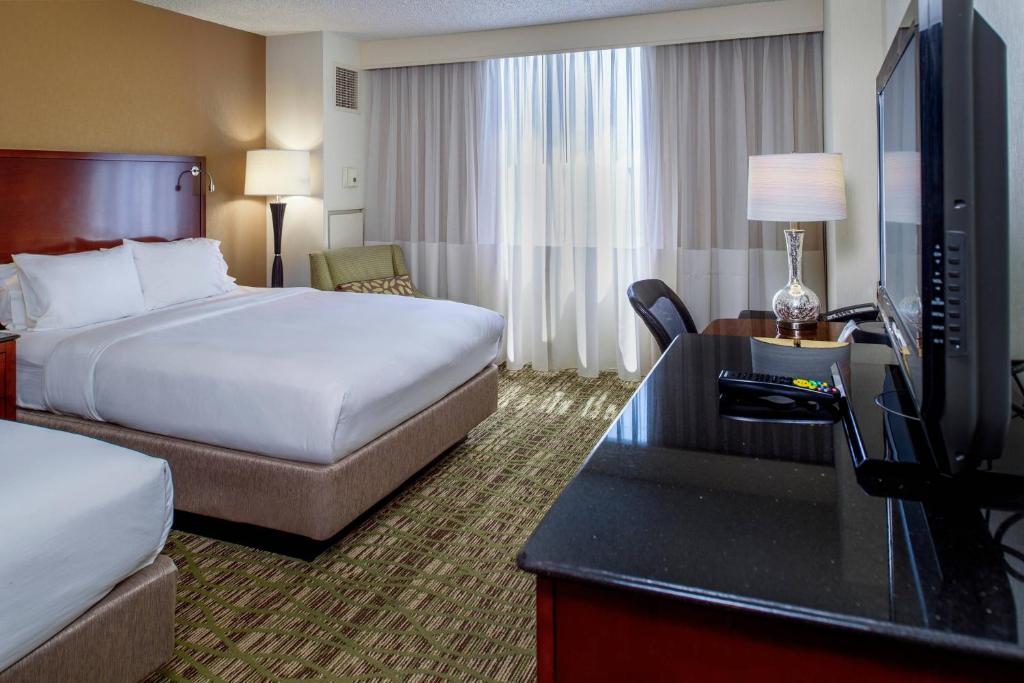 a hotel room with a bed and a television at Marriott St. Louis West in Chesterfield