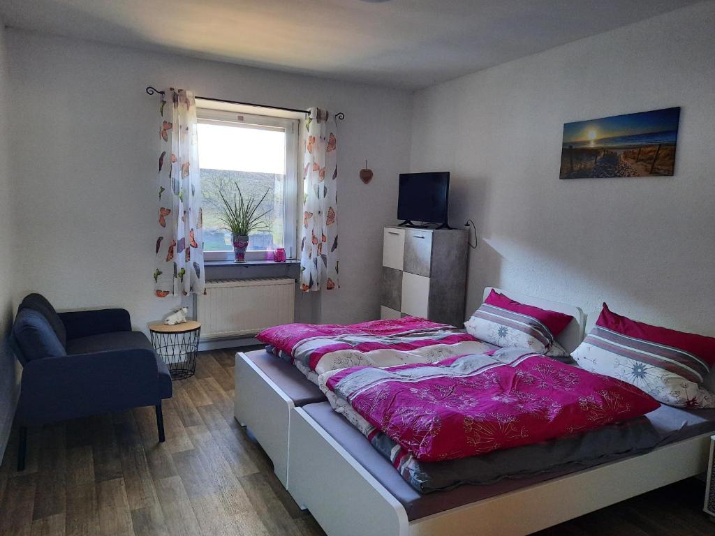 a bedroom with a large bed and a window at Ferienwohnung am Rittershof Heusweiler in Heusweiler