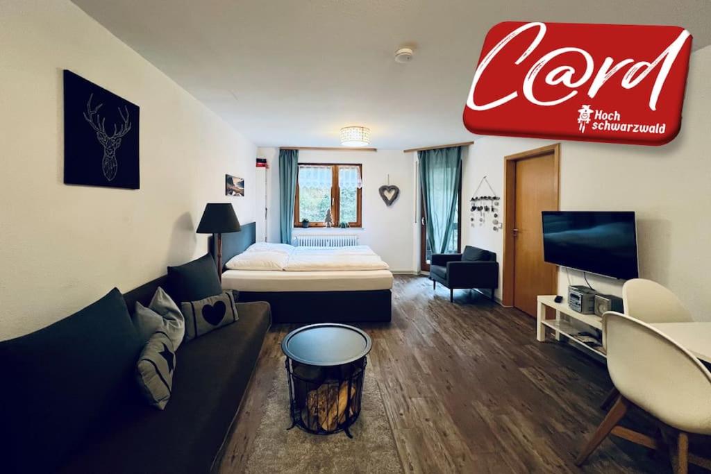 a living room with a couch and a bed at Waldtwin 2 Titisee (W12) + Hochschwarzwald Card in Titisee-Neustadt
