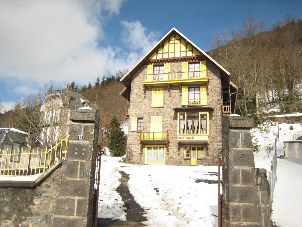 a large brick house in the snow at Le Mont Dore Résidence Cottage rez de chausse in Le Mont-Dore