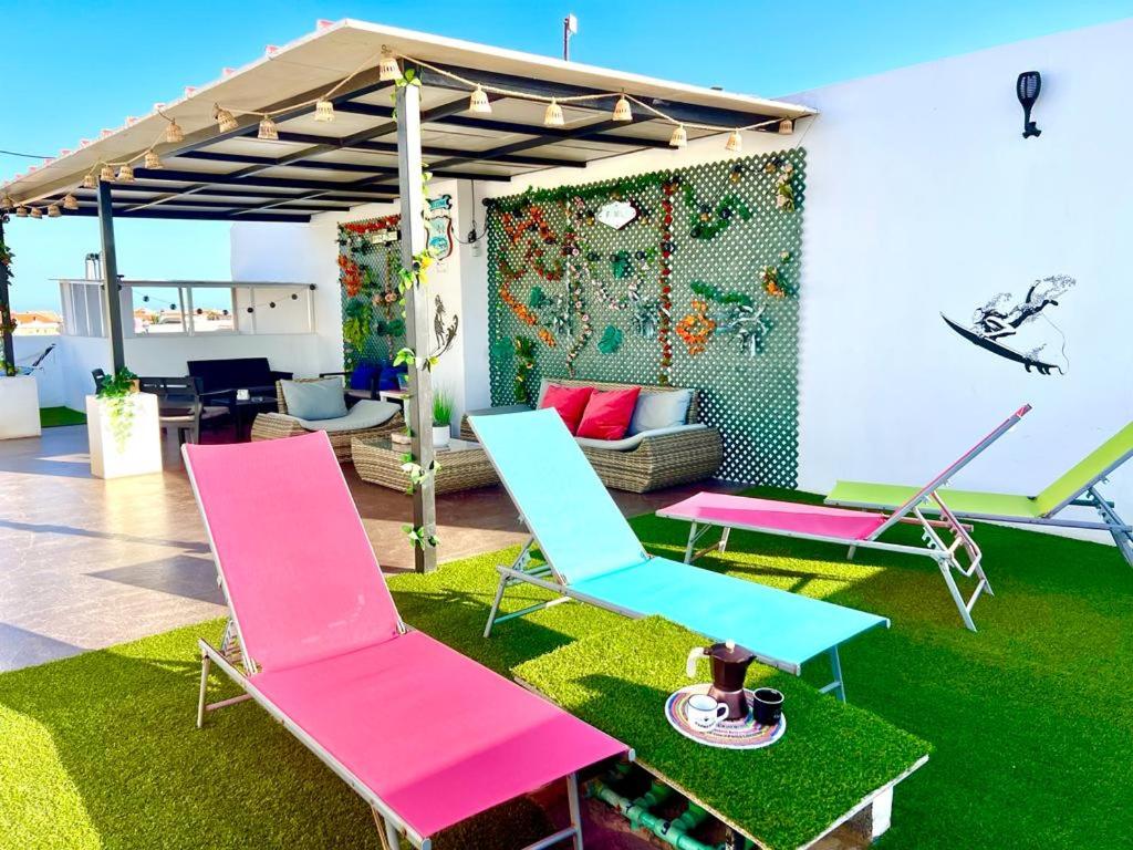 a group of chairs sitting on grass in a room at Animos! Apartments - 10 modern apartments near the city & beach, perfect for nomads, travellers, families, watersports! in Santa Maria