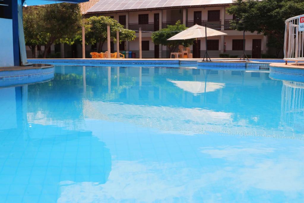 a large swimming pool with blue water at Hotel Pousada da Lapa in Bom Jesus da Lapa