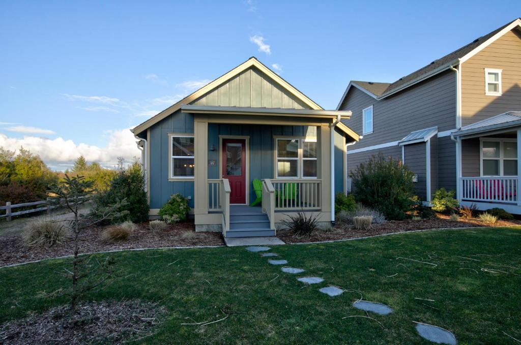 a house with a red door and a yard at Willowbridge Cottage in Ocean Shores