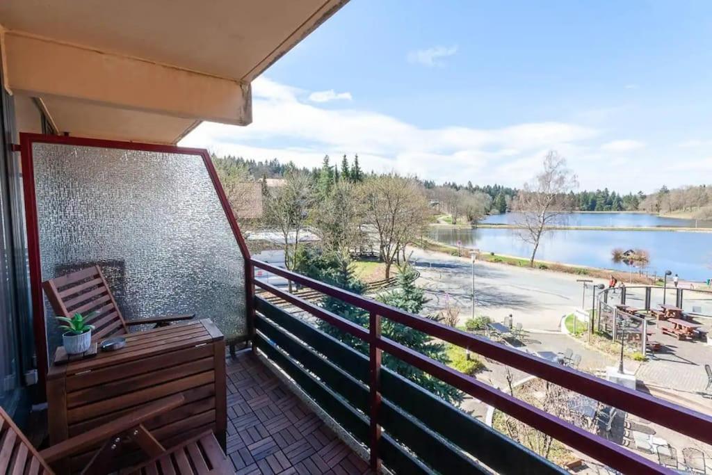 a balcony with a bench and a view of a lake at Ferienwohnung Kranichsee 2 in Goslar