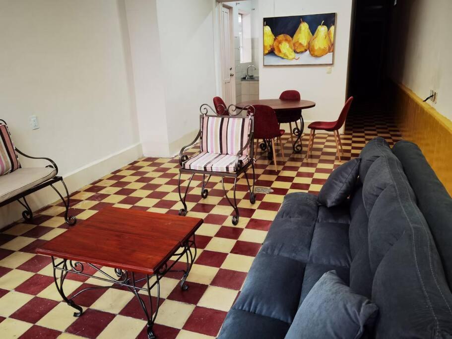 ein Wohnzimmer mit einem blauen Sofa und einem Tisch in der Unterkunft Amplio y acogedor -2D 1B in Tuxpan de Rodríguez Cano