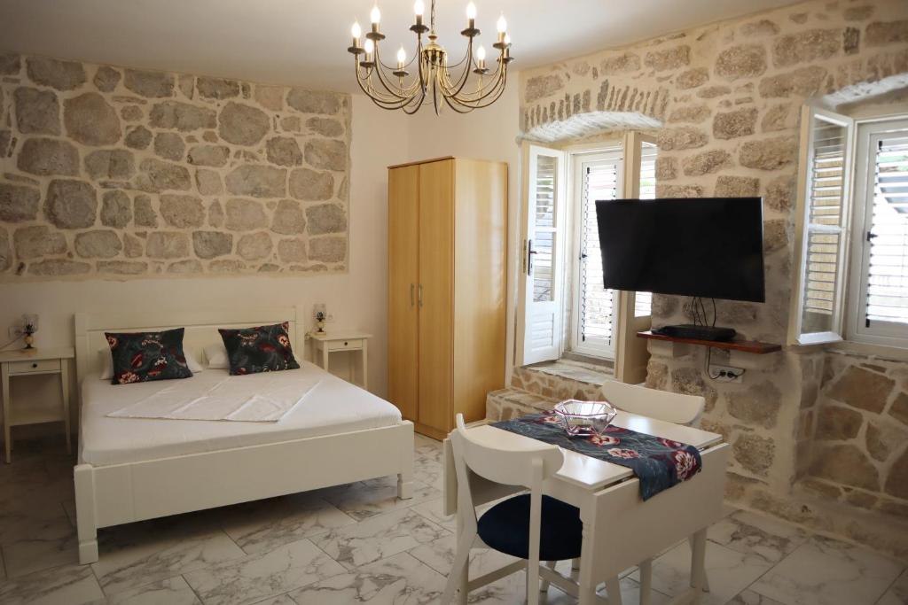Schlafzimmer mit einem Bett, einem Tisch und einem TV in der Unterkunft Guesthouse Žmukić in Perast