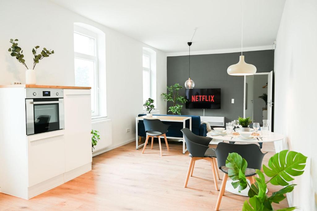 een keuken en eetkamer met een tafel en stoelen bij 50qm Apartment in Krefeld zentral gelegen mit hohen Decken - BEUYS Apartments - Krefeld in Krefeld