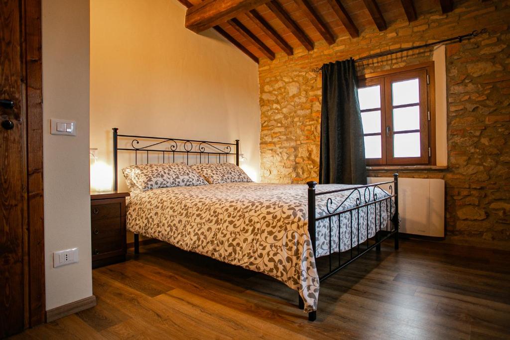 ein Schlafzimmer mit einem Bett in einem Zimmer mit einem Fenster in der Unterkunft Agriturismo Fonte Belvedere in Collesalvetti