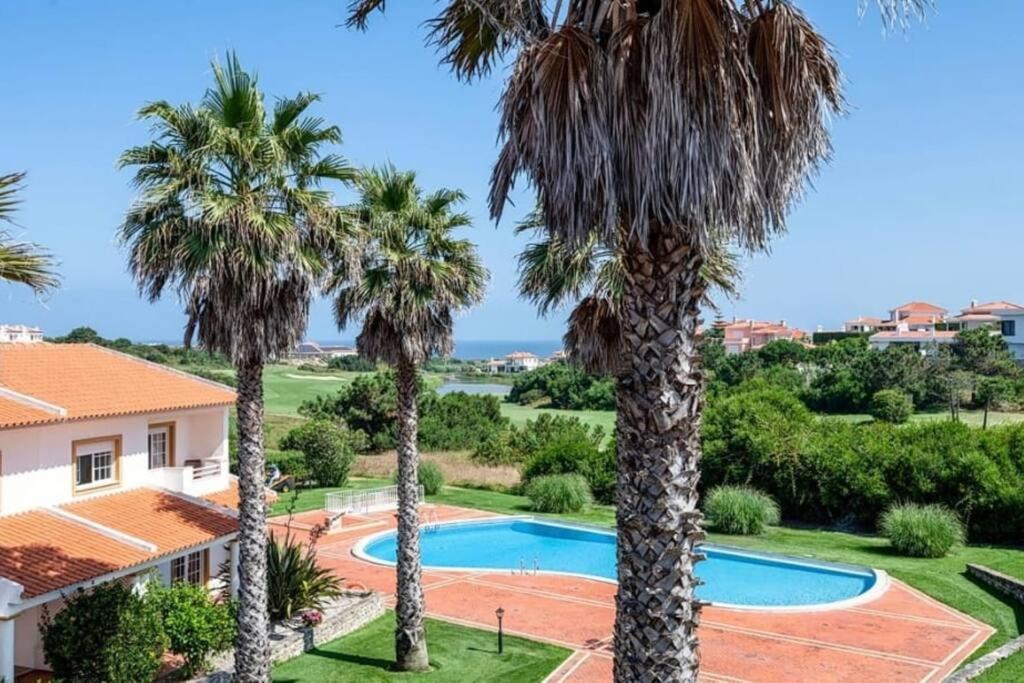 a villa with a swimming pool and palm trees at Pool-Golf-Ocean resort home in Praia Del Rey in Amoreira
